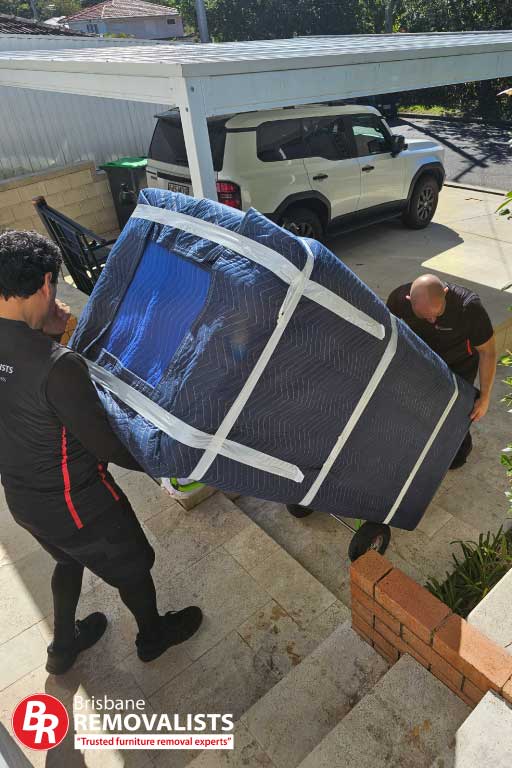 Removalists New Farm. Image of 2 of our movers taking a wrapped fridge down stairs