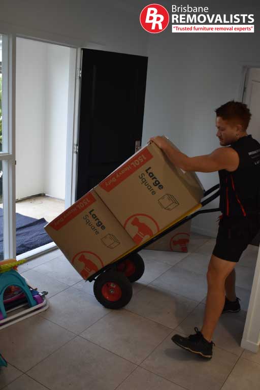Removalists Deception Bay image of a team member trolleying out boxes